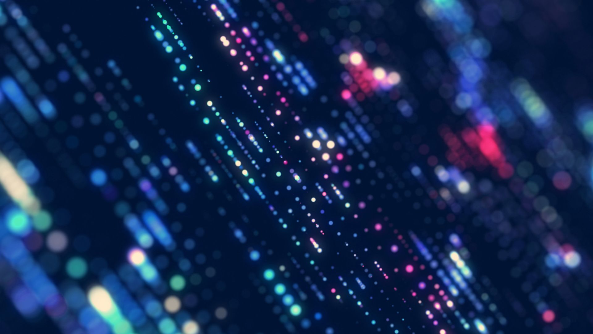 Colorful, glowing digital data streams in a blurred, abstract pattern against a dark background, resembling a futuristic technological visualization.