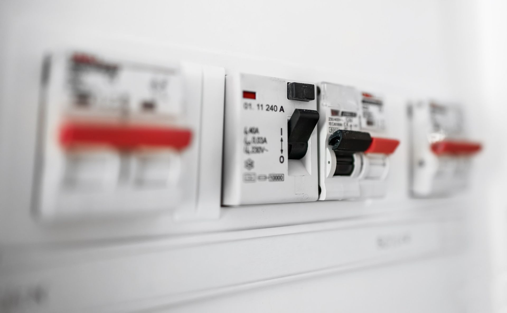 Sicherungskasten mit mehreren elektrischen Schaltern und Sicherungen. Die Schalter sind beschriftet und einige sind in der Position „Ein“.