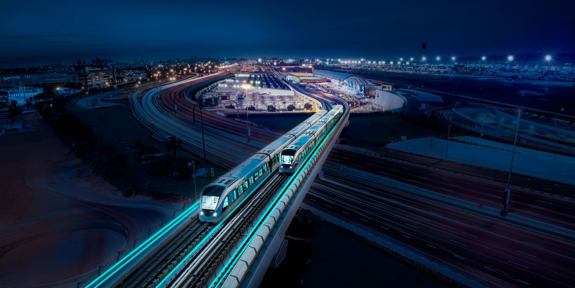 Aerial view of a modern train moving along elevated tracks at night, surrounded by city lights and bustling transportation infrastructure.