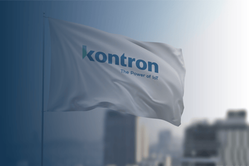 Eine weiße Fahne mit dem Logo "kontron" und dem Slogan "The Power of IoT" weht vor einem unscharfen städtischen Hintergrund.
