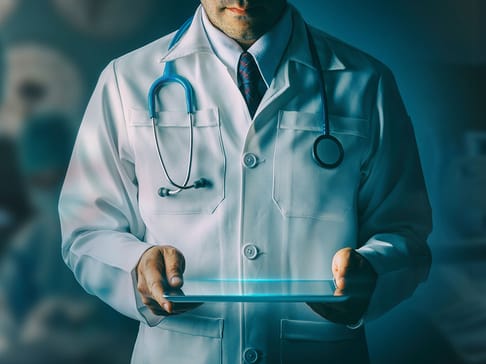 Médecin en blouse blanche tenant une tablette numérique, avec un stéthoscope autour du cou. Une atmosphère technologique et professionnelle se dégage de l'image.