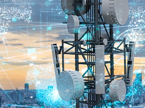 Ein Telekommunikationsturm steht vor einer Stadtlandschaft, umgeben von grafischen Datenübertragungsmustern und einem Sonnenuntergang.