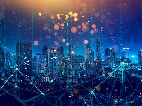 A vibrant city skyline at night, illuminated by colorful lights with a digital overlay of glowing lines and binary code, suggesting connections and data flow.