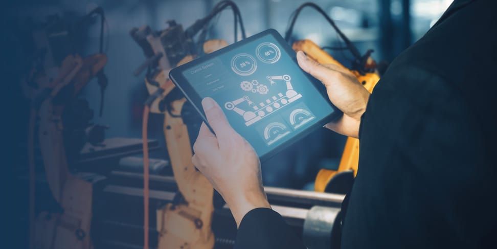 Eine Person hält ein Tablet mit einer Anwendung zur Überwachung von Robotern in einer industriellen Umgebung. Im Hintergrund sind Roboterarme sichtbar, die in einer Fertigungsstätte arbeiten.